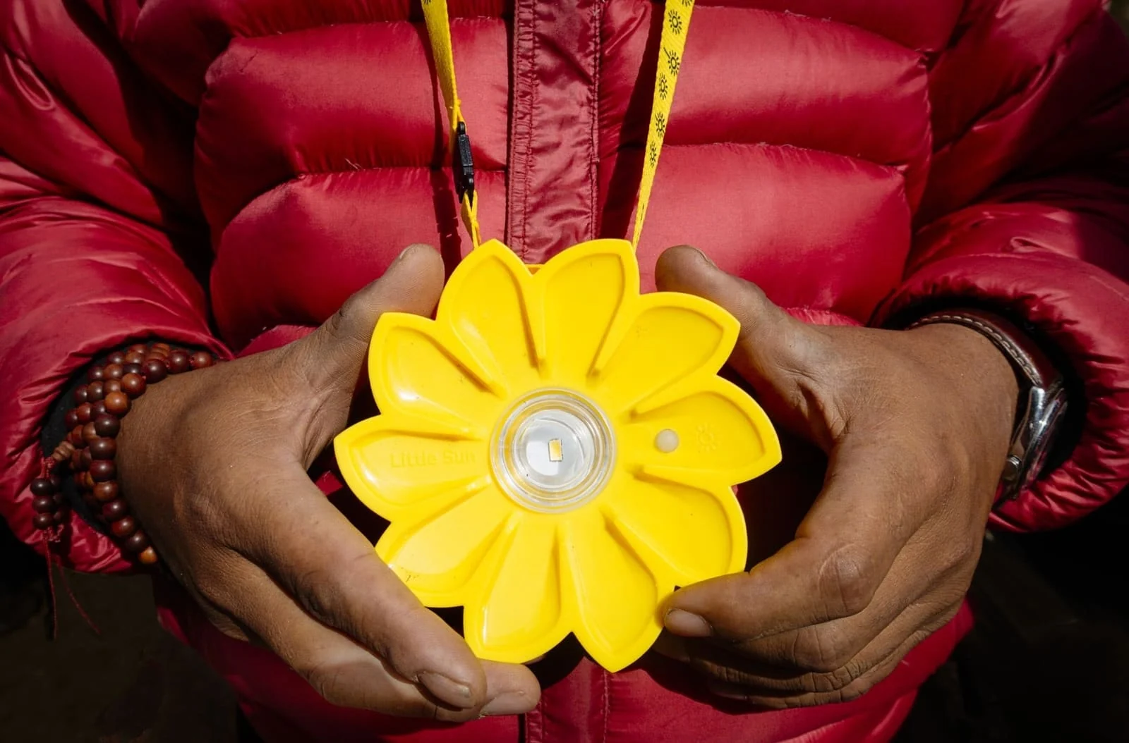 A child holding a Little Sun solar light