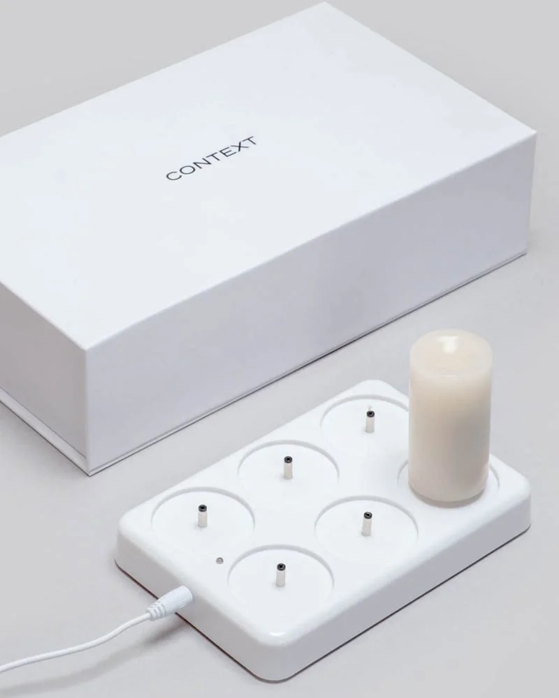 One candle seated on the included six-position USB charging dock
