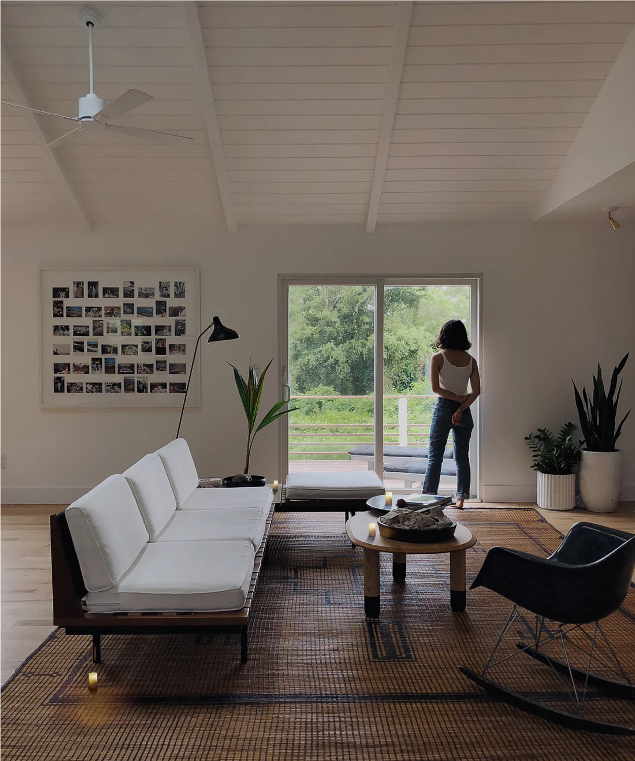 Context candles on the coffee tables, beside the sofa and on the rug in a sunlit living room